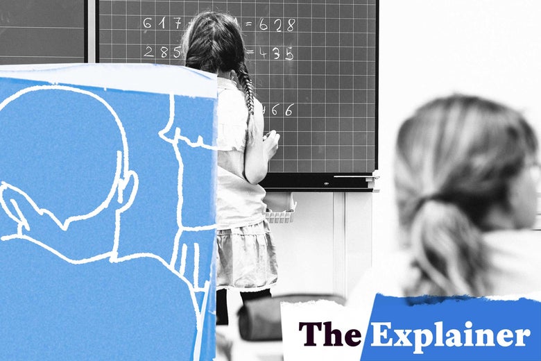 A girl does a math problem on a chalkboard in school.