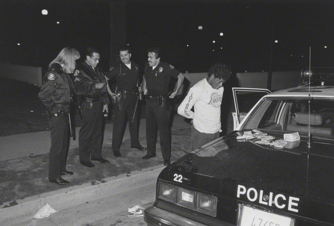 66/7/86 Agent Olquin holding rock cocaine piece found in drug sales suspect's folded money. Sunset Avenue.