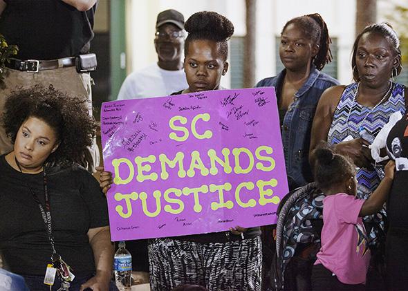 A protester holds a sign during a late rally at city hall in Nor,A protester holds a sign during a late rally at city hall in North Charleston, South Carolina April 8, 2015.