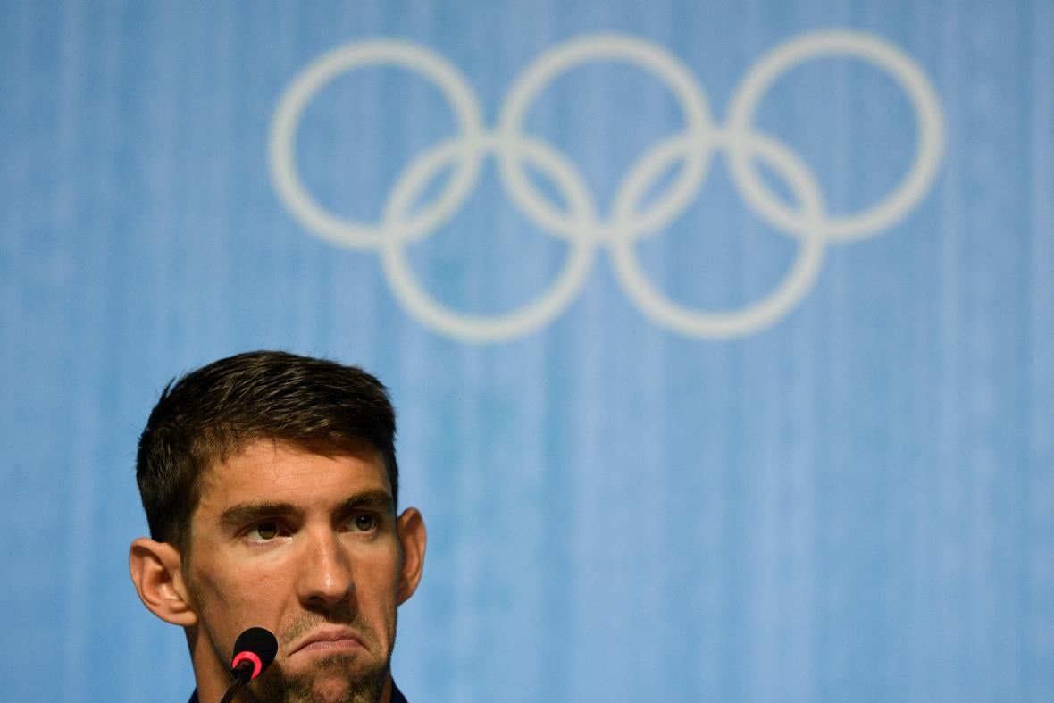 Phelps at a microphone and frowning