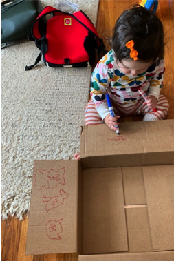 A child drawing on an Amazon box.