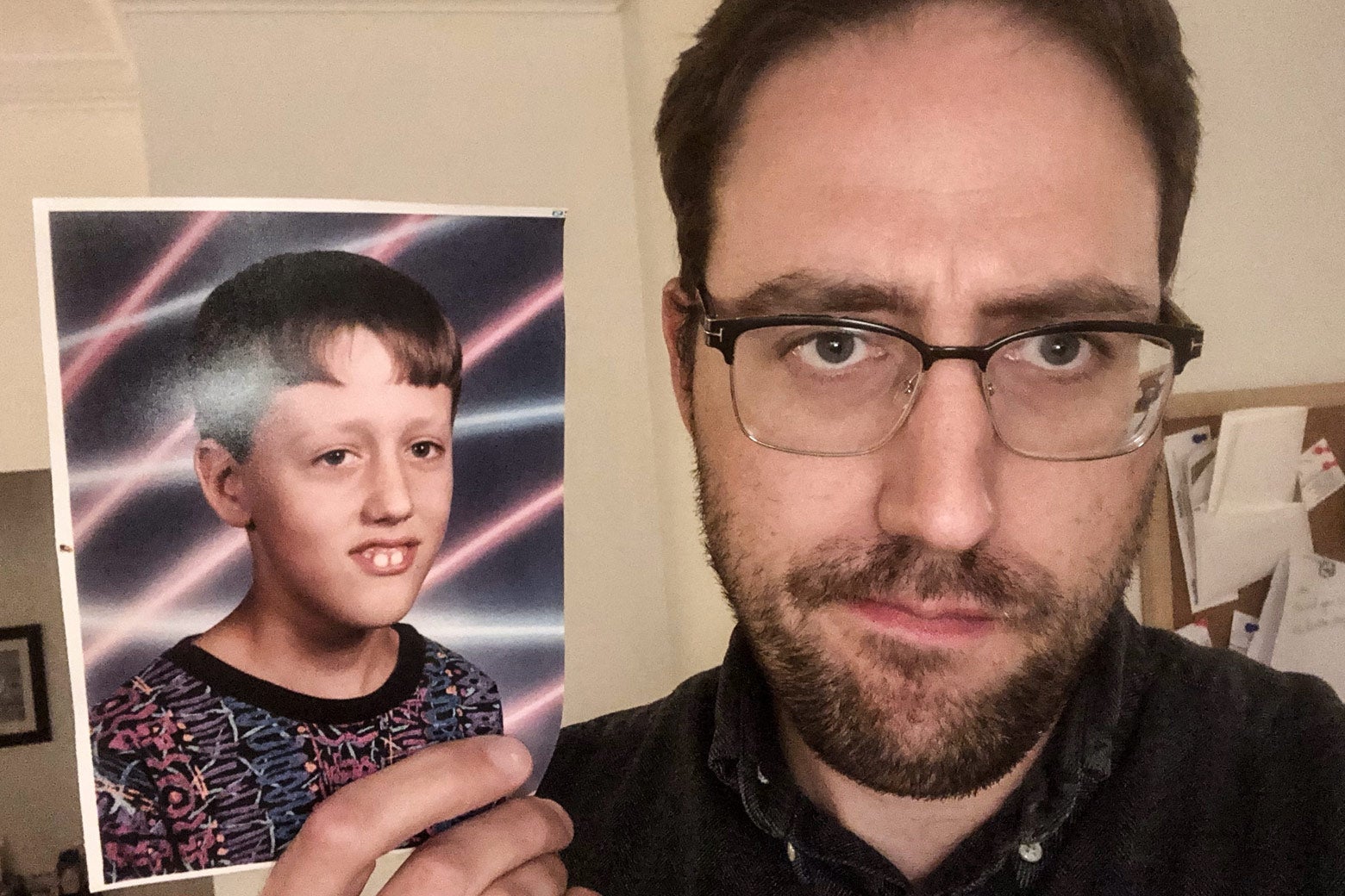 Adrian Smith next to his third grade photo.