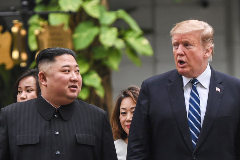 Kim and Trump converse while walking side by side outdoors.