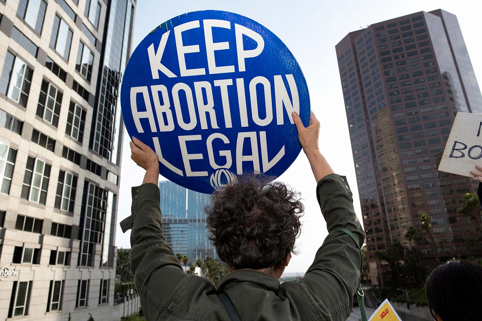 A protester holds up a sign reading "KEEP ABORTION LEGAL."