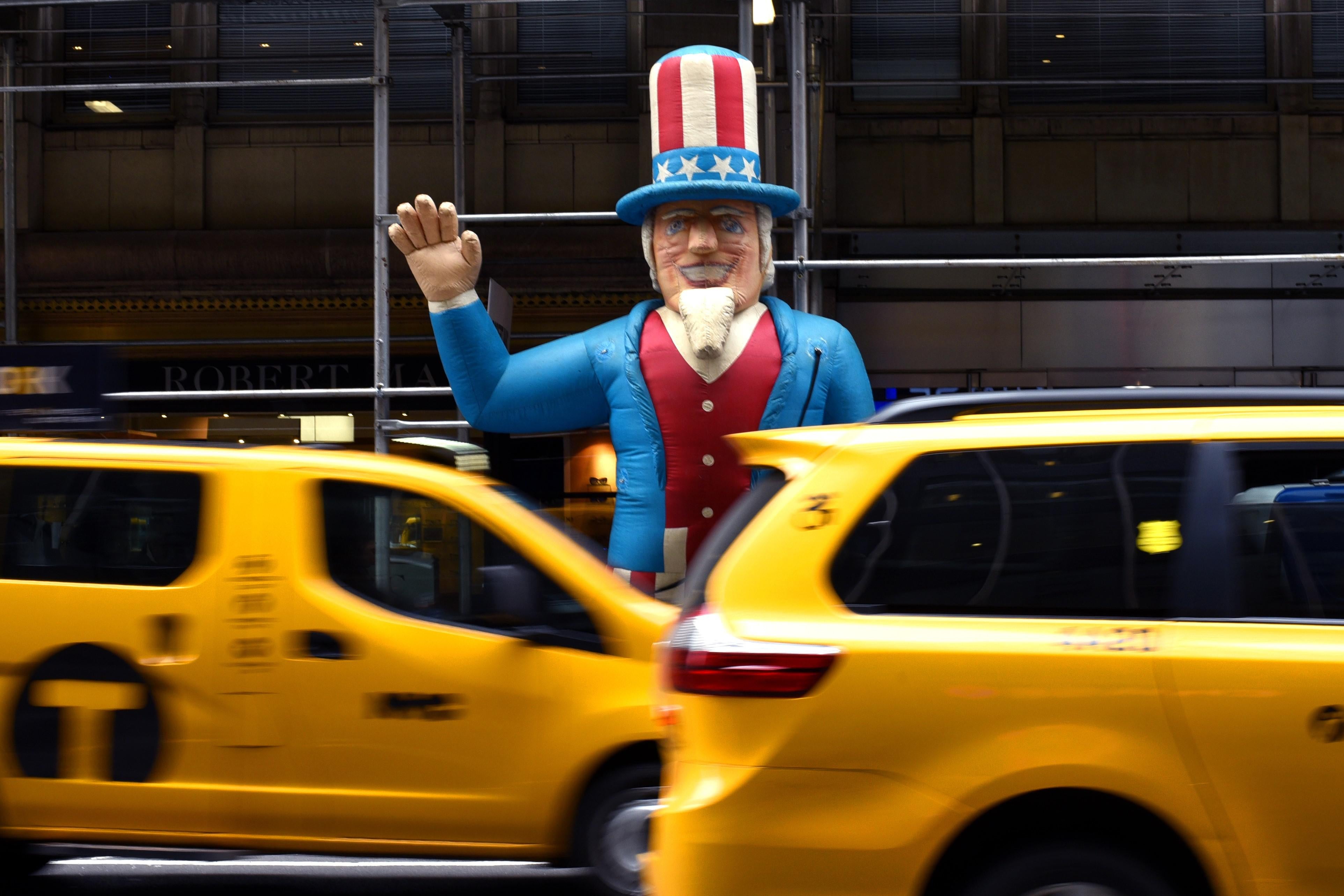 New York City cabs pass by a  balloon of 'Uncle Sam' in front of a building on Madison Avenue in New York March 1, 2018. 