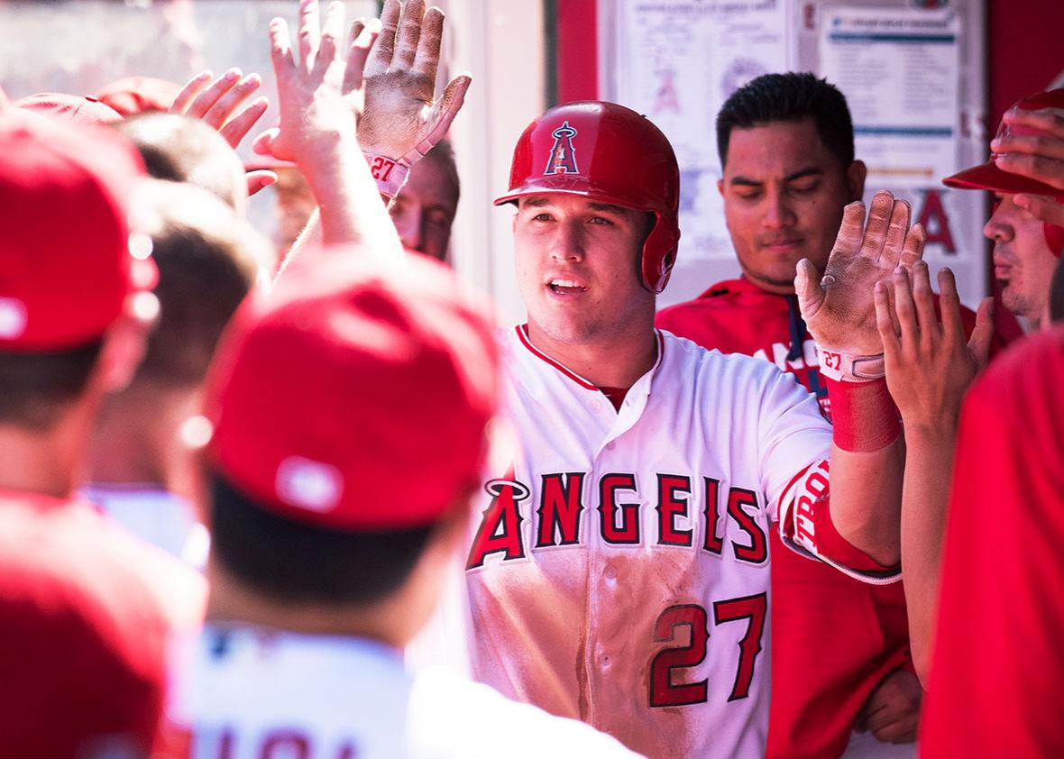 Los Angeles Angels of Anaheim Center field Mike Trout greeted by his teammates after being lifted for a pinch running after he drove in a run for his 100th RBI of the season during the game against the Houston Astros played at Angel Stadium of Anaheim in Anaheim, CA.