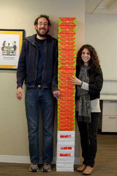 Two people standing by paper.