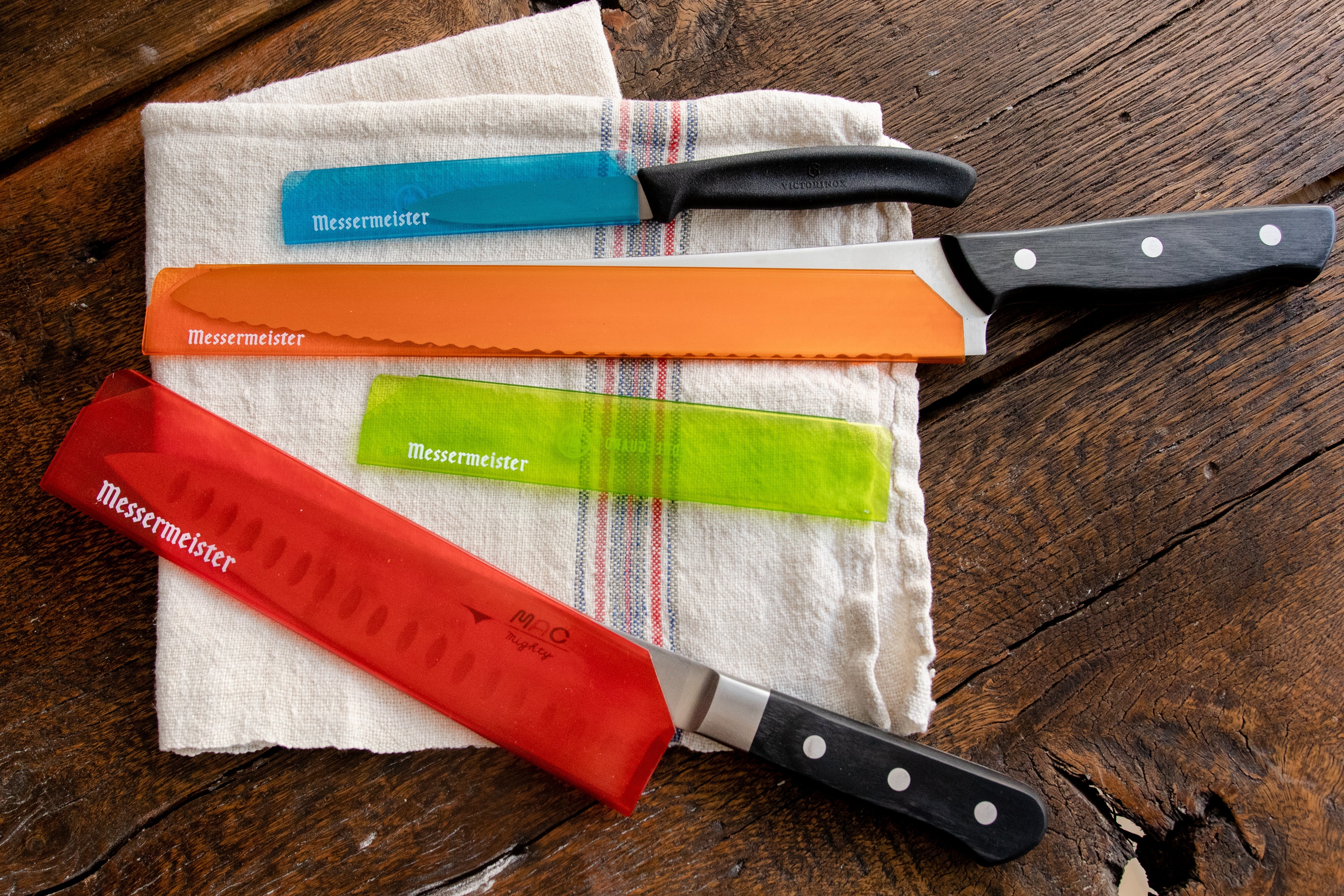 Messermeister knives inside colorful see-through blade guards.