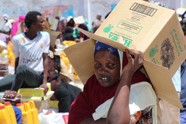 An internally displaced woman shades her head from the heat of the sun during food distribution in Mogadishus Shingani district just outside of the Somali capital on May 15, 2019.