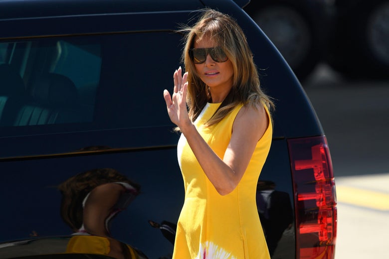Melania Trump waves as she approaches a black SUV