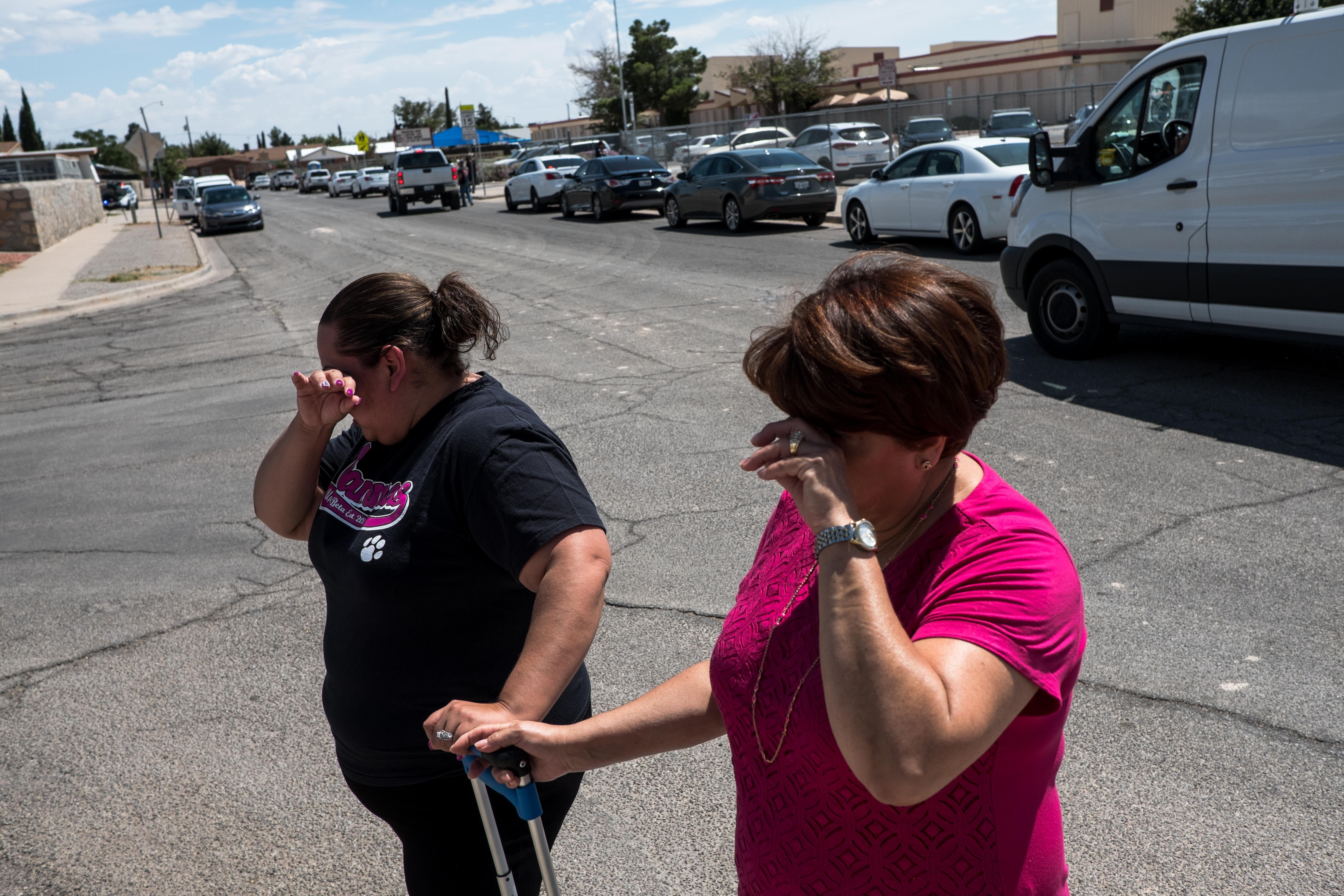Erica and Alma Rios cry on the street outside the school.