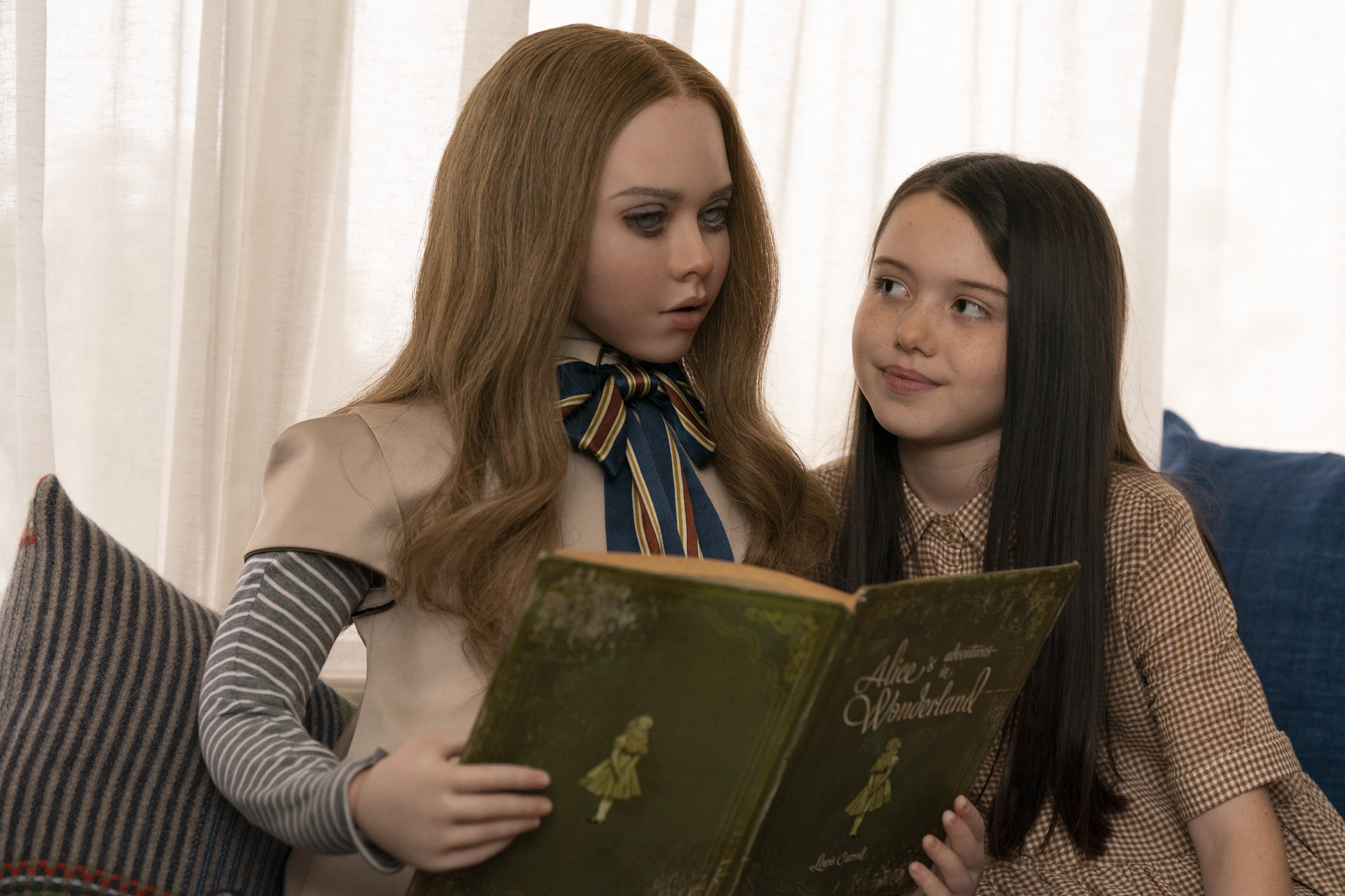 A dead-eyed American Girl-looking robot doll reads an old copy of Alice in Wonderland to a similarly dressed young girl as she looks on fondly
