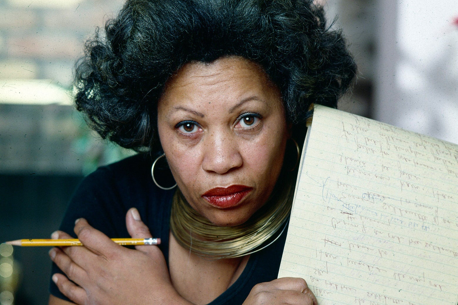 Toni Morrison holds a legal pad and pencil.