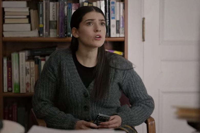 A female student sits on a chair in Bill's office.