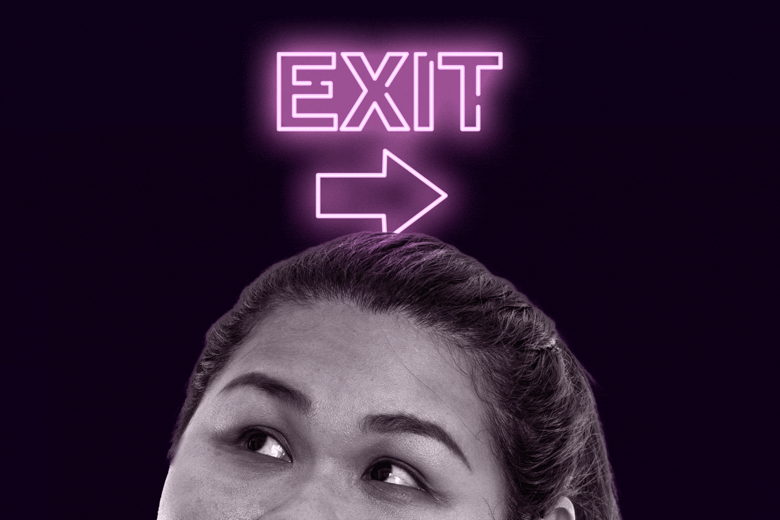 Woman looking up at an exit sign.