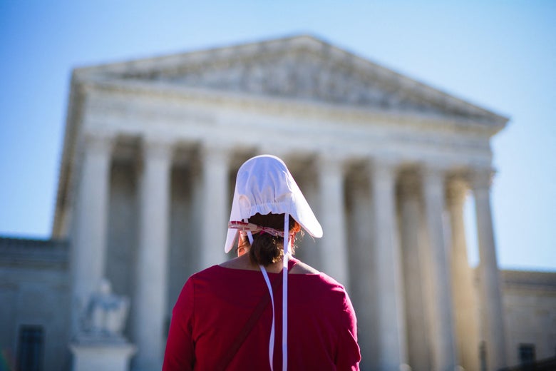 A pro-choice demonstrator dressed in Handmaid's Tale garb standing in front of the Supreme Court. 