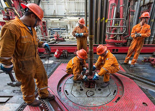 A team removes a drilling tool with a sample of the marine seabed at an oil rig in the Gulf of Mexico