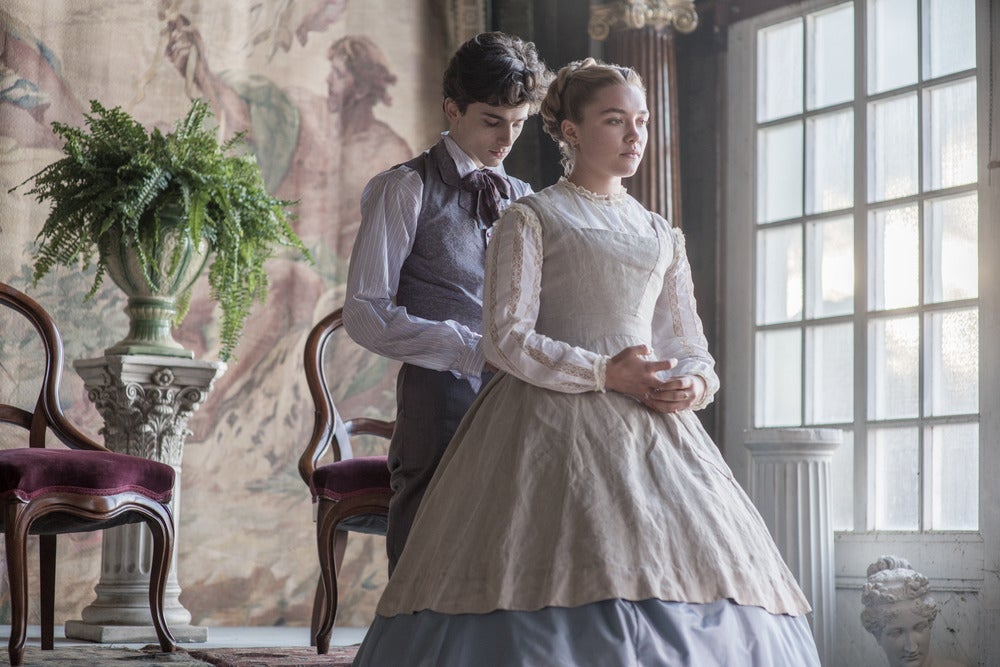 In a scene from Little Women, Chalamet stands behind Pugh, looking down as if buttoning the back of her dress.