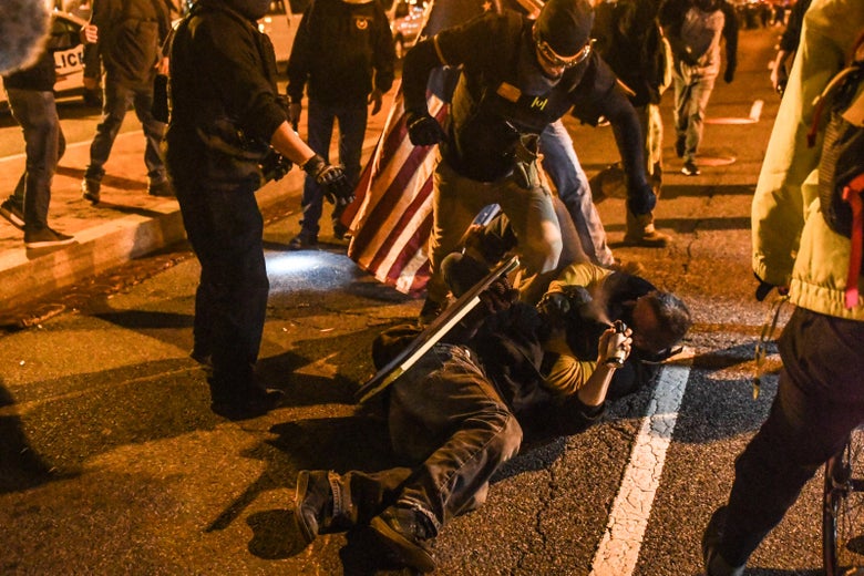 Members of the Proud Boys kick a member of Antifa on the ground during a protest on December 12, 2020 in Washington, D.C.