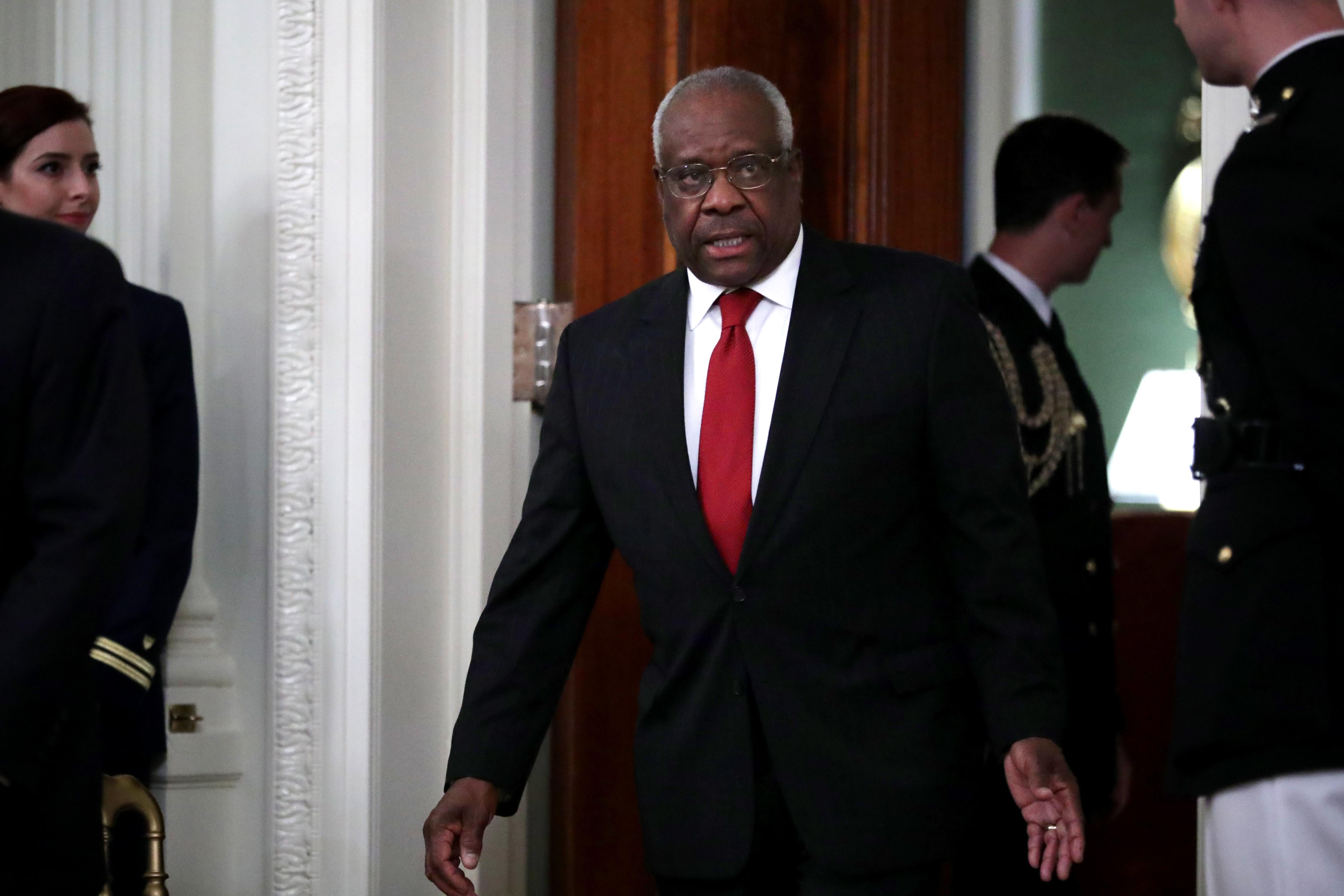 Justice Clarence Thomas walks into a room with a decisive stride.
