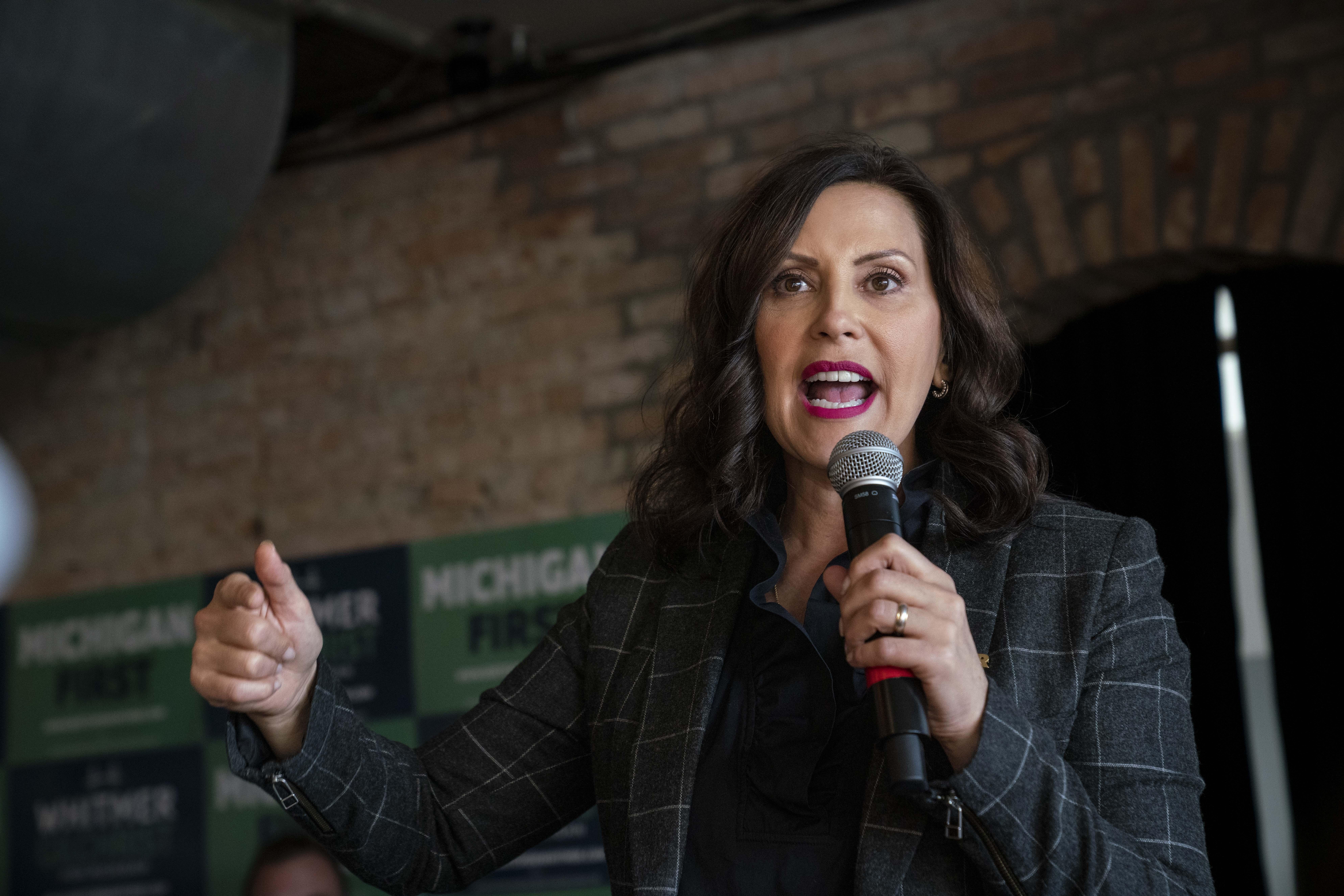 Gretchen Whitmer holding a mic while speaking and gesticulating