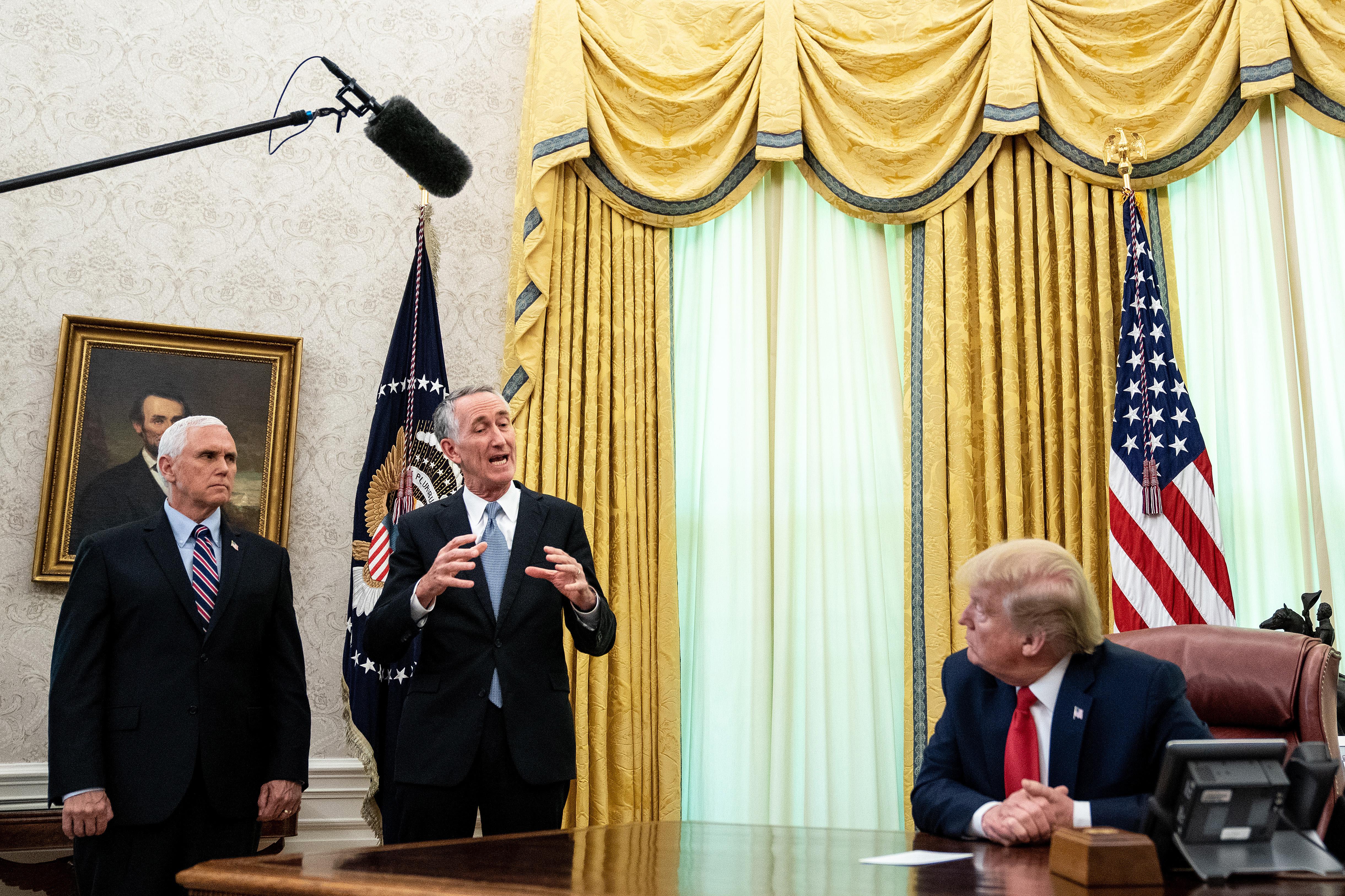 Pence and O'Day stand in the Oval Office while Trump sits behind his desk.