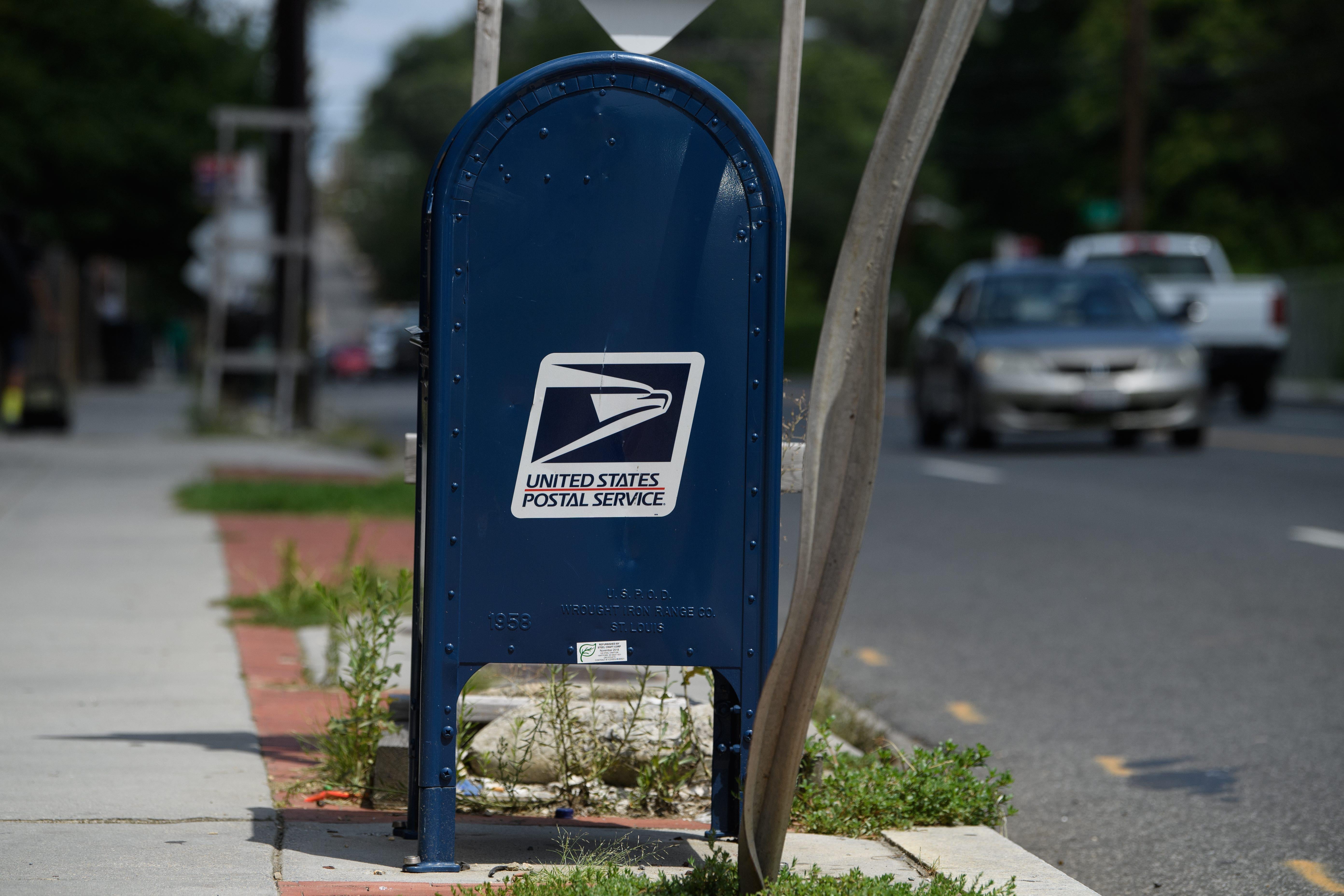 A United States Postal Service (USPS) mailbox stands in front of a post office in Washington, DC, on August 18, 2020. - The US Postal Service said on August 18 it will halt changes blamed for slowing mail delivery until after the November election, changing course in the wake of the political firestorm President Donald Trump ignited when he acknowledged he wanted to undermine the agency. (Photo by NICHOLAS KAMM / AFP) (Photo by NICHOLAS KAMM/AFP via Getty Images)