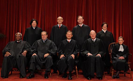 U.S. Supreme Court members pose for photographs in the Supreme Court building.