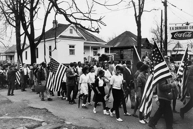 Participants, some carrying American flags, march from Selma to Montgomery, Alabama, in 1965