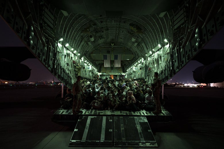 Crowded evacuees seen through the open berth of a military plane awaiting evacuation.