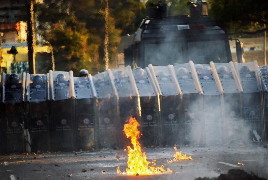 Members of the National Police protect themselves during an anti-government protest in Caracas on Feb. 19, 2014.