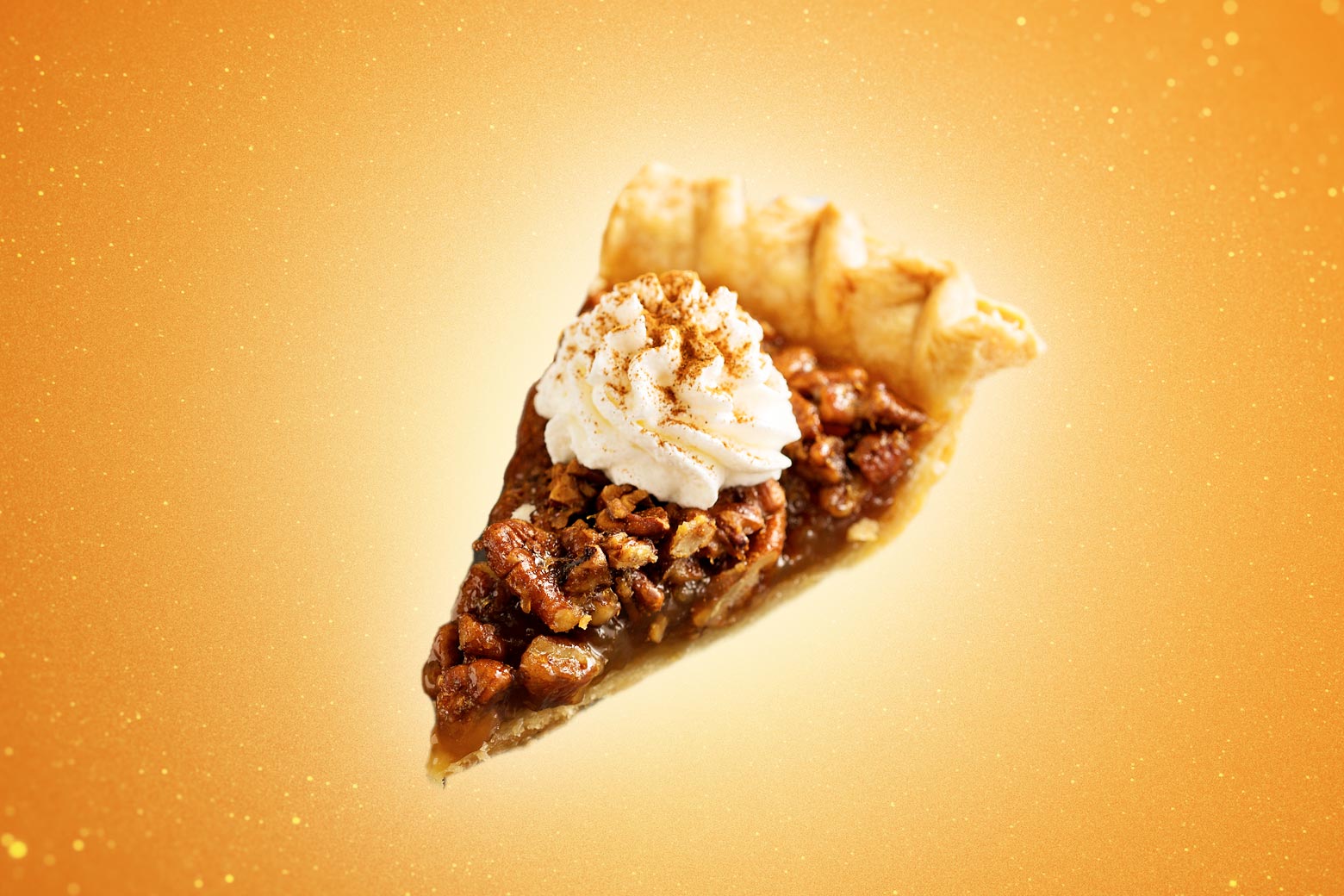A slice of pecan pie, with whipped cream on top, in front of a gold background.