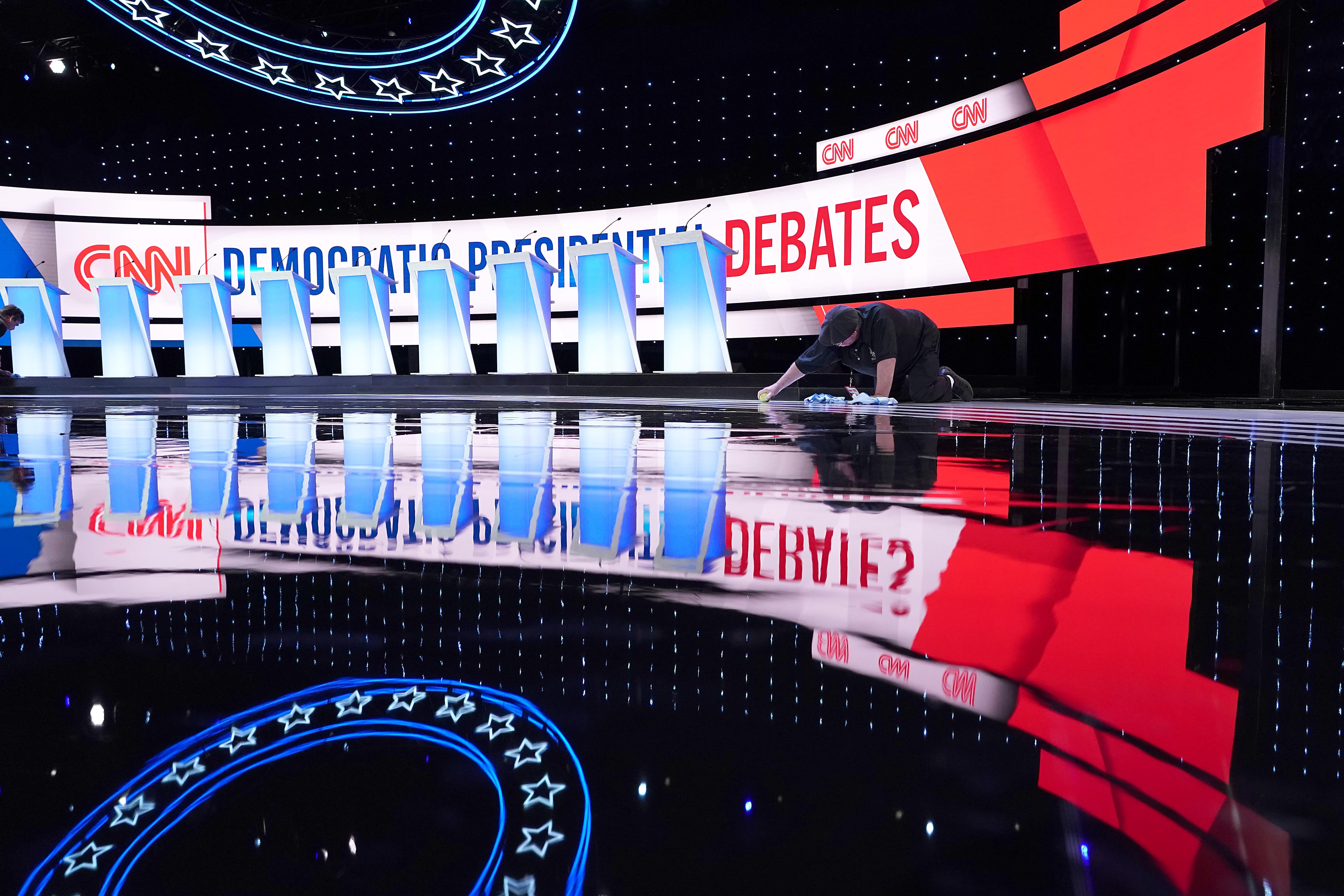 A worker cleans the empty debate stage.