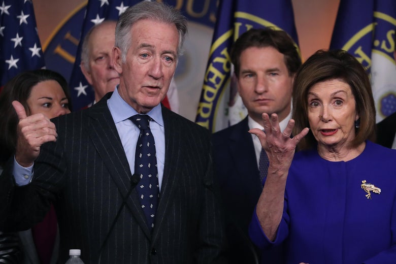 Richard Neal gestures from behind a podium with Nancy Pelosi and other House Democrats beside him.