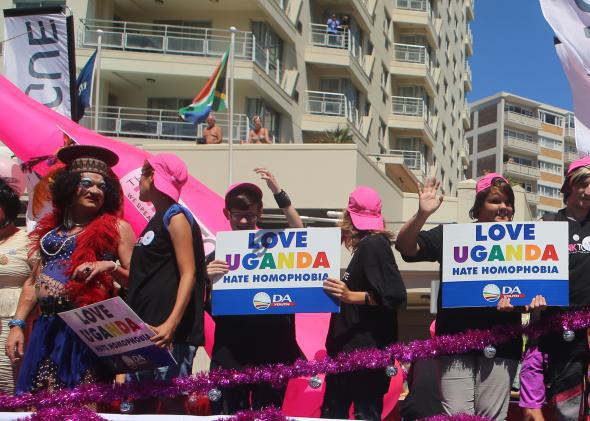 People hold "Love Uganda, Hate Homophobia" signs in Cape Town's 2014 Gay Pride Parade. 