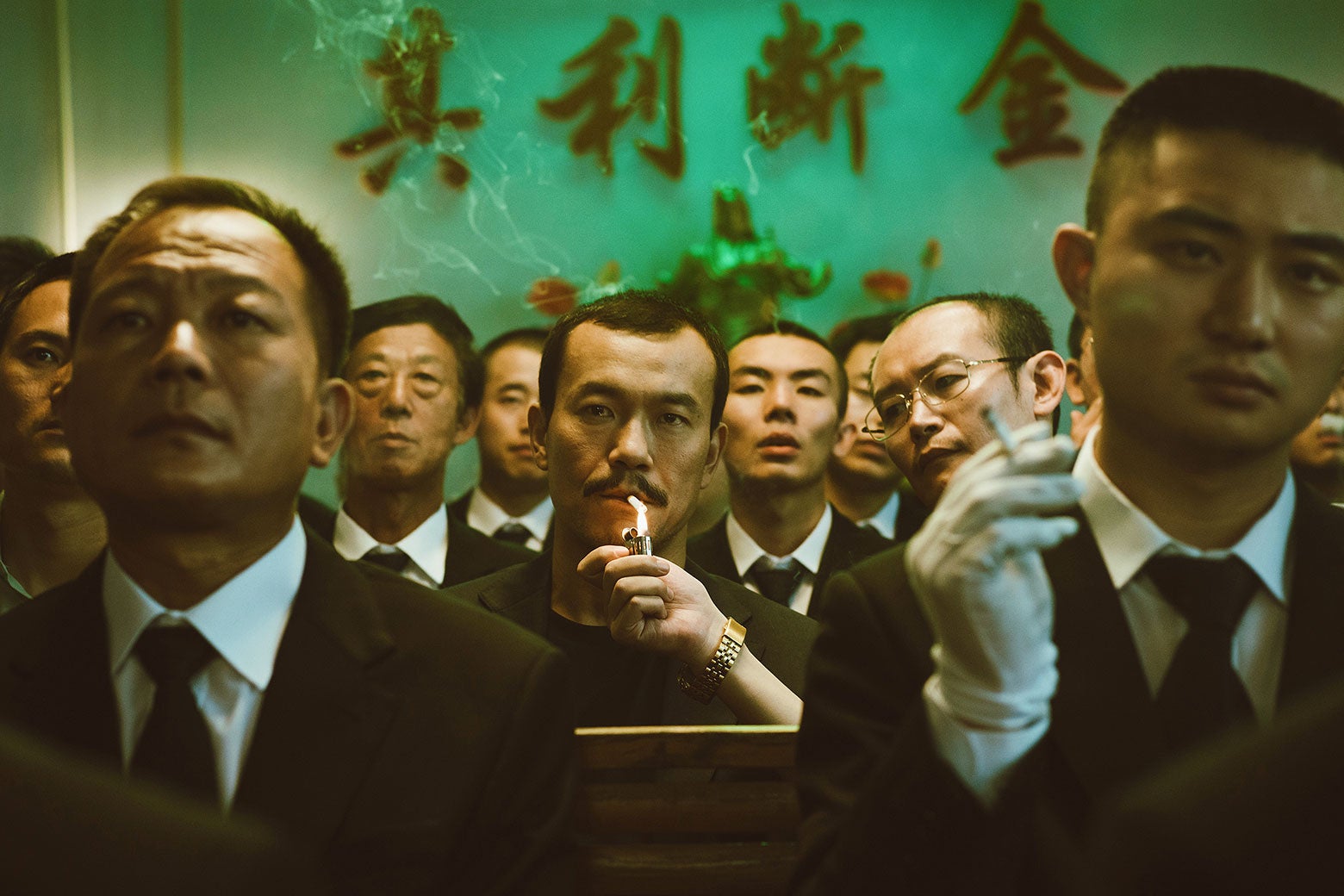 Bin lighting a cigarette in a crowded space in Ash Is Purest White.