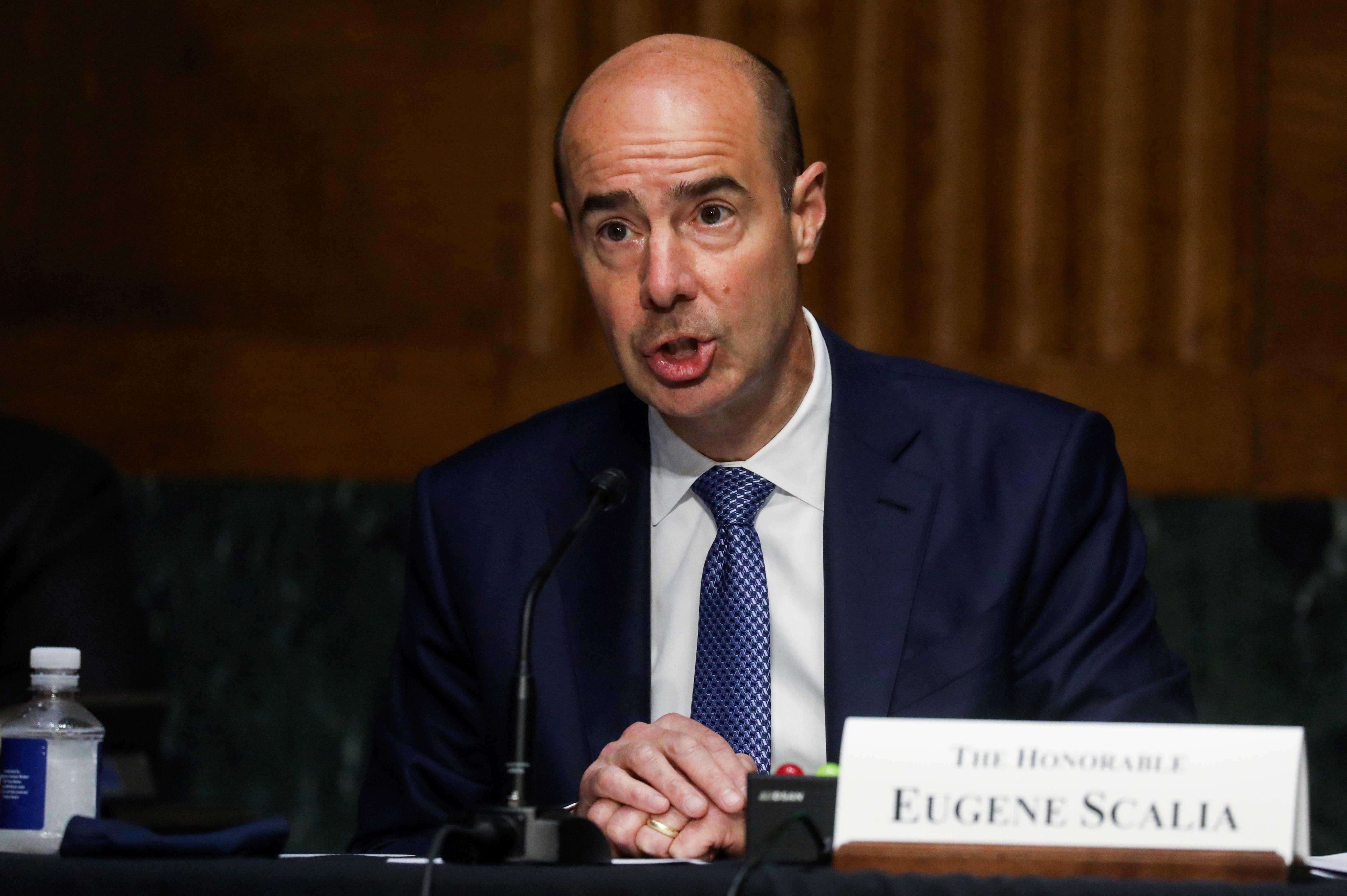Scalia's mouth open as he testifies in a blue suit and tie.