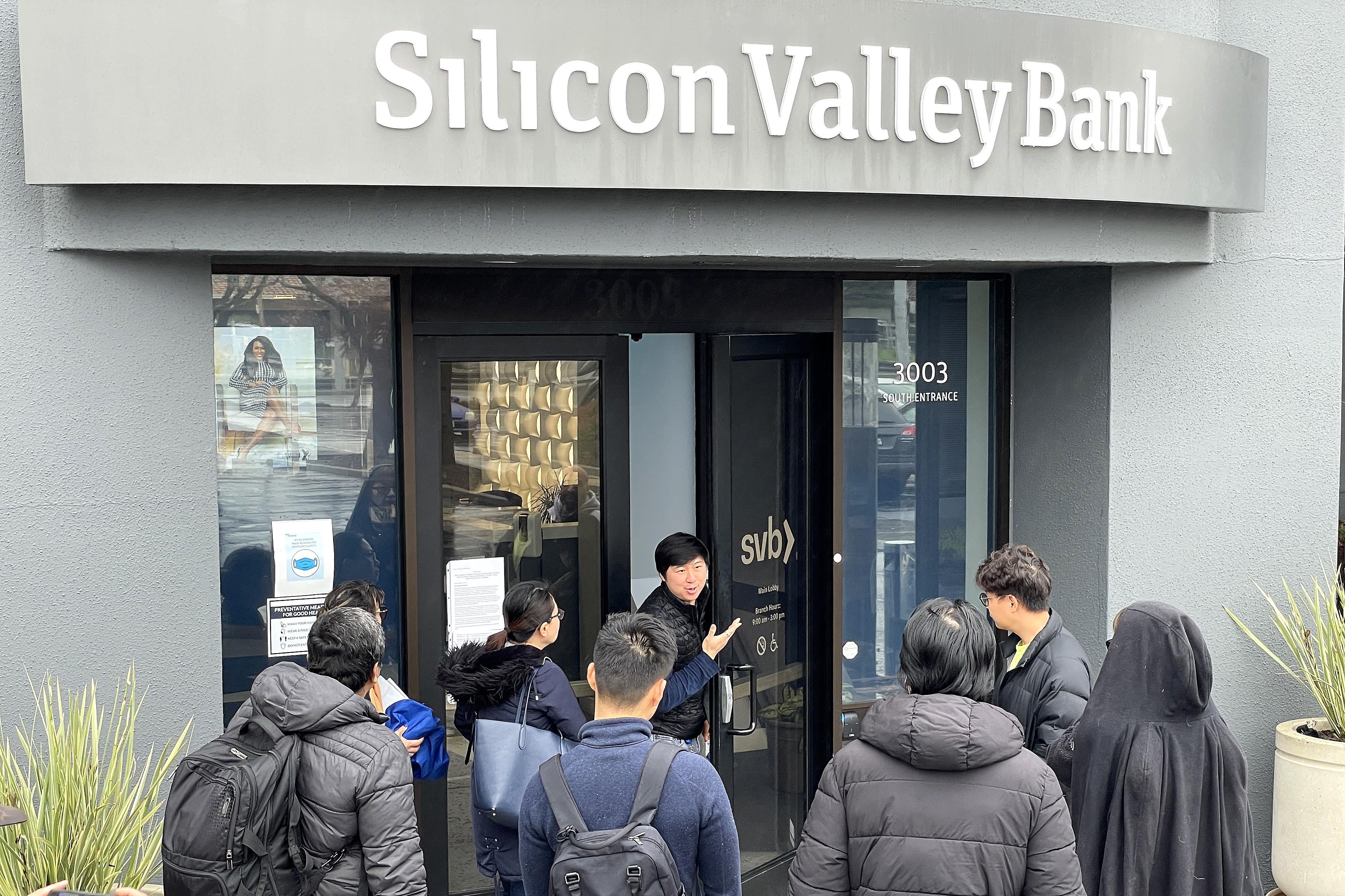 SANTA CLARA, CALIFORNIA - MARCH 10: A worker (C) tells people that the Silicon Valley Bank (SVB) headquarters is closed on March 10, 2023 in Santa Clara, California. Silicon Valley Bank was shut down on Friday morning by California regulators and was put in control of the U.S. Federal Deposit Insurance Corporation. Prior to being shut down by regulators, shares of SVB were halted Friday morning after falling more than 60% in premarket trading following a 60% declined on Thursday when the bank sold off a portfolio of US Treasuries and $1.75 billion in shares to cover declining customer deposits. (Photo by Justin Sullivan/Getty Images)
