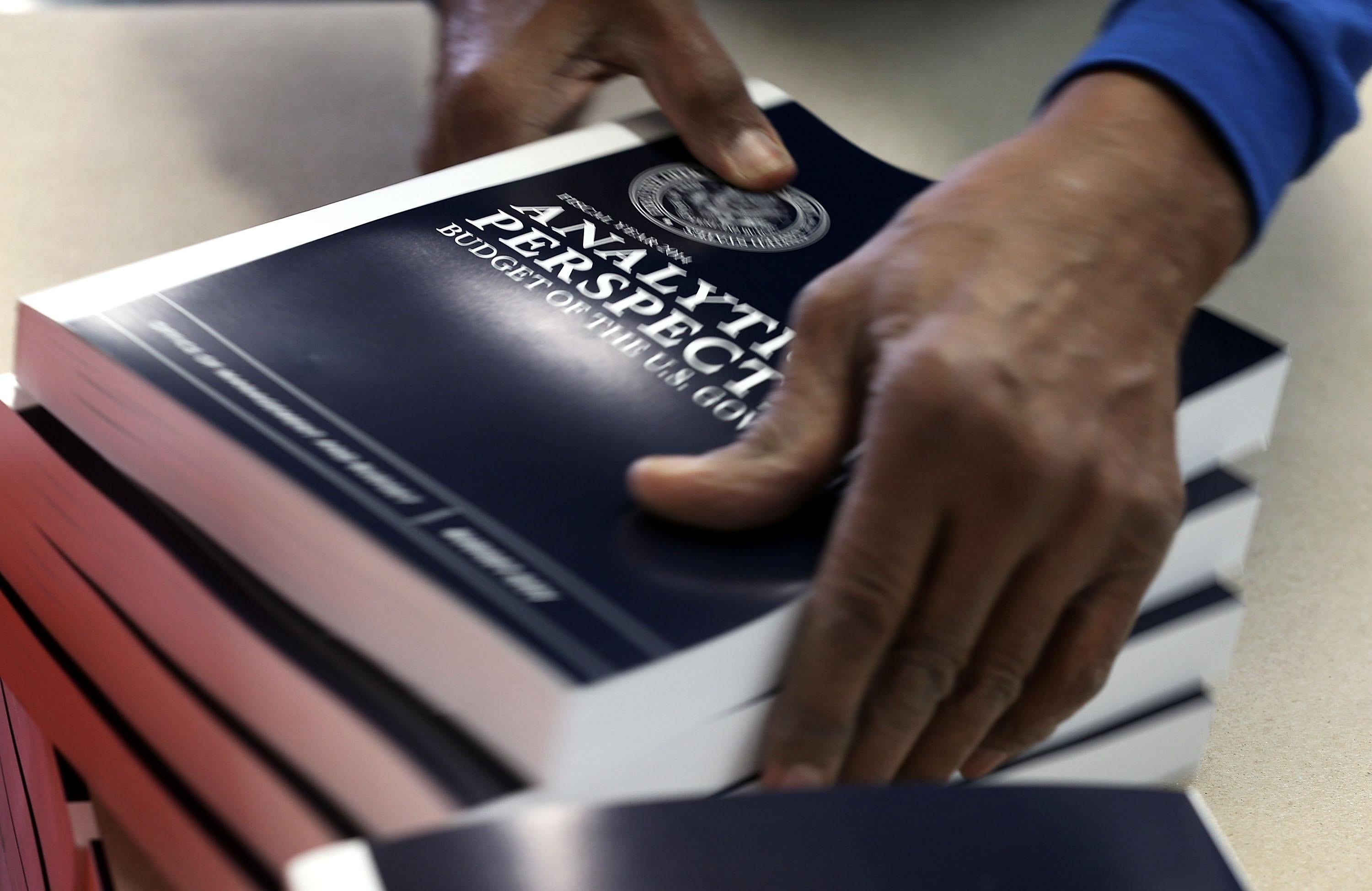 A worker stacks copies of U.S. President Barack Obama's budget proposal for FY 2014.