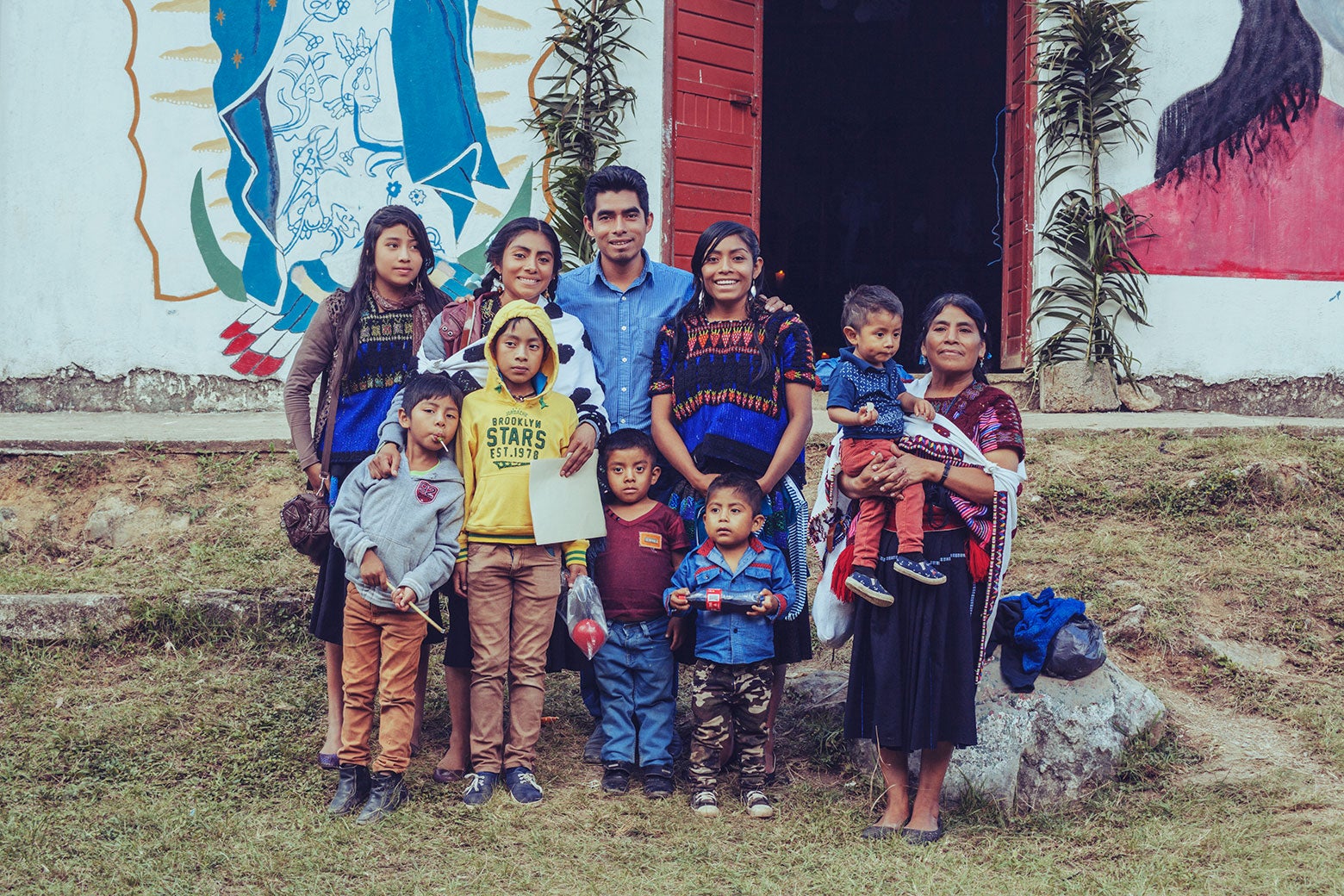 Lupita standing with her brothers and sisters, the aunt who cared for them after their parents died, and their children.