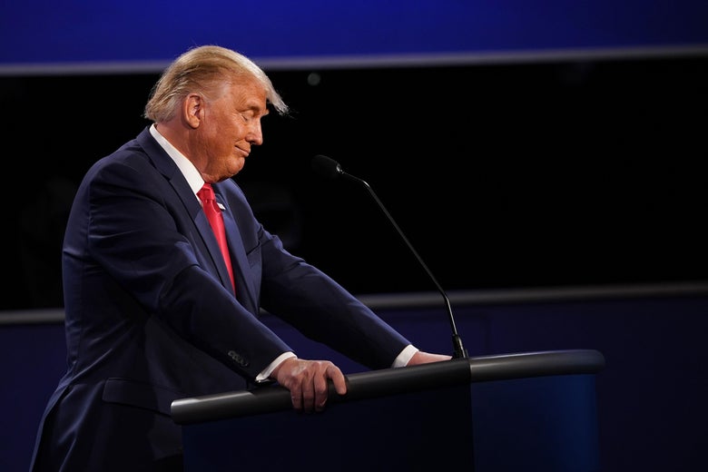 Trump smirks as he stands at his lectern on the debate stage