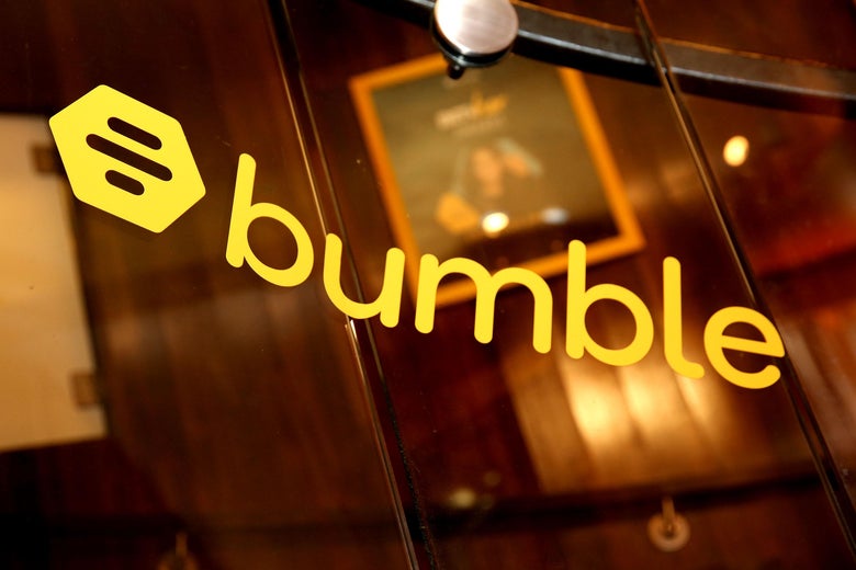 The logo for Bumble, a yellow bee hive, is printed on a glass wall.