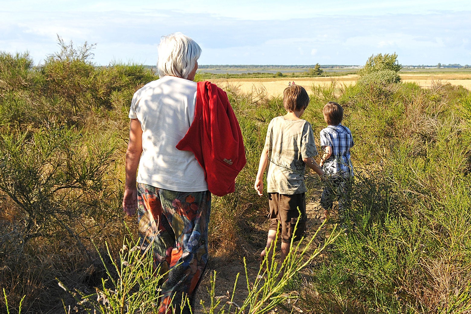 A grandmother keeping her distance while hiking with two grandchildren.