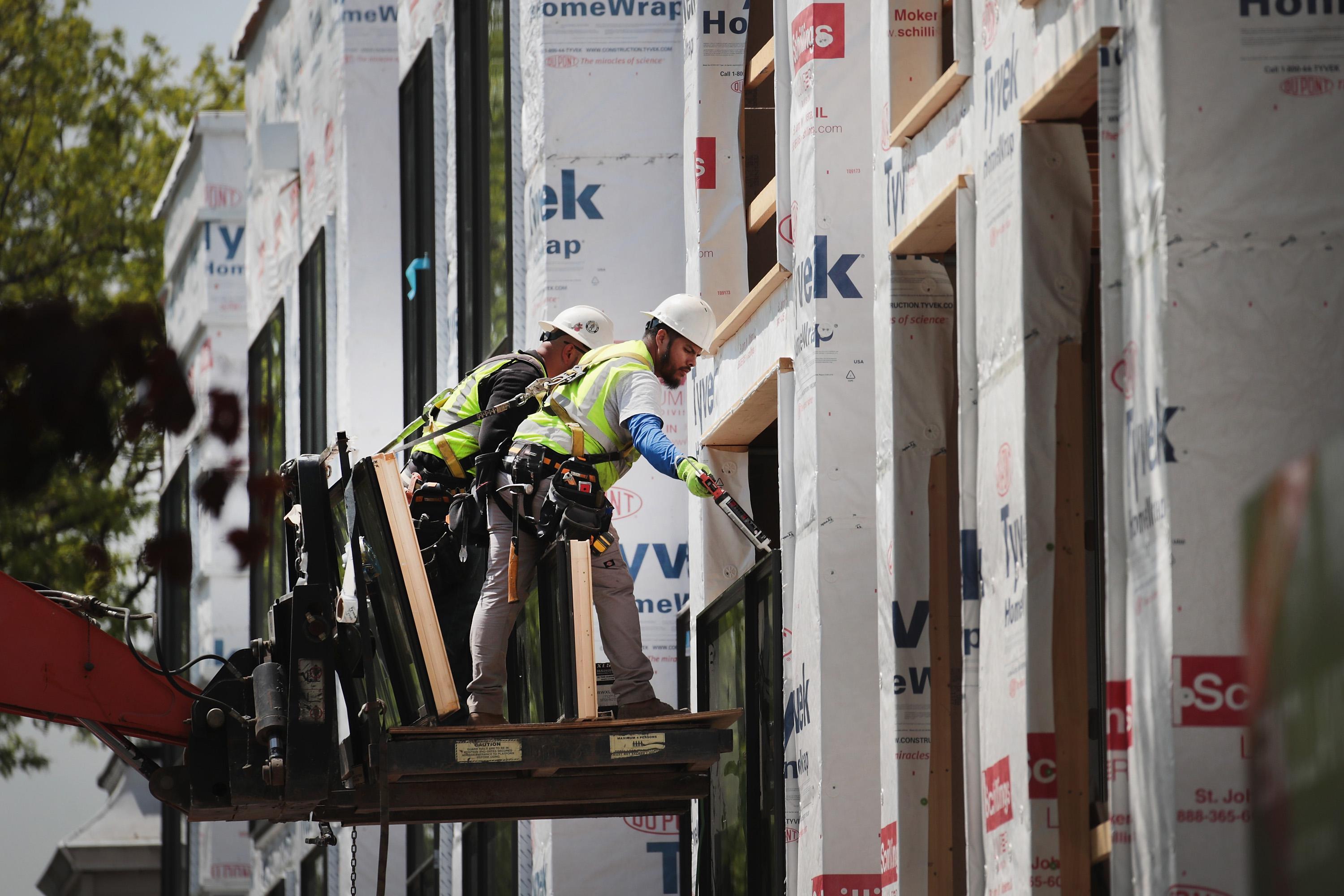 CHICAGO, IL - MAY 15:  Workers install windows in a townhome complex under construction on May 15, 2017 in Chicago, Illinois. The National Association of Home Builders said today that its housing-market index rose by two points in May, a signal of a strengthening housing market. New home construction statistics for April will be released by the United States Census Bureau on May 16.  (Photo by Scott Olson/Getty Images)