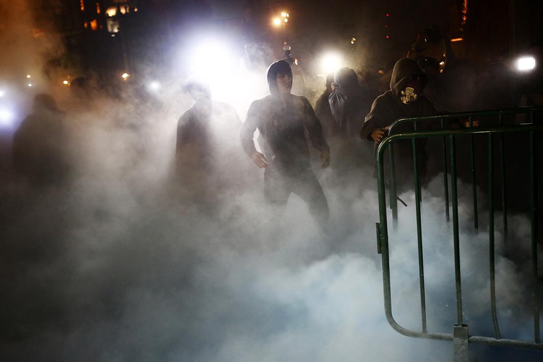 Protesters stand amidst smoke outside the palace on Nov. 8. 