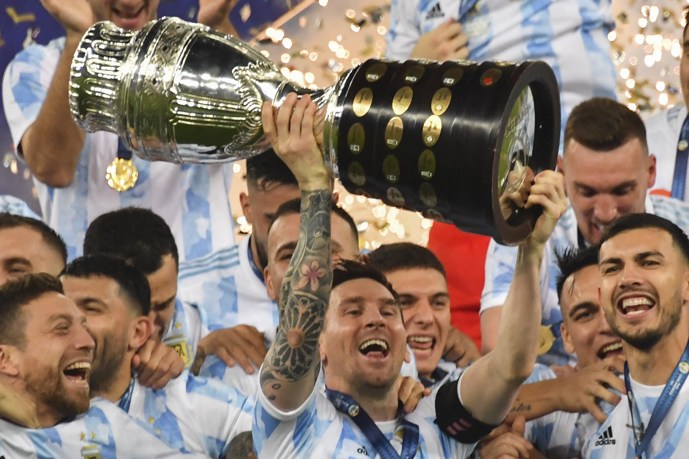 Argentina's Lionel Messi holds the trophy as he celebrates on the podium with teammates after winning the Conmebol 2021 Copa America football tournament final match against Brazil at Maracana Stadium in Rio de Janeiro, Brazil, on July 10, 2021.