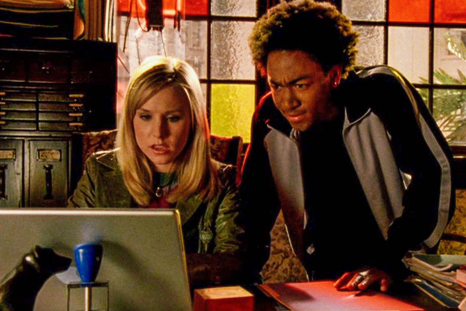 Bell as Veronica working at a computer and Daggs as Wallace looking over her shoulder.