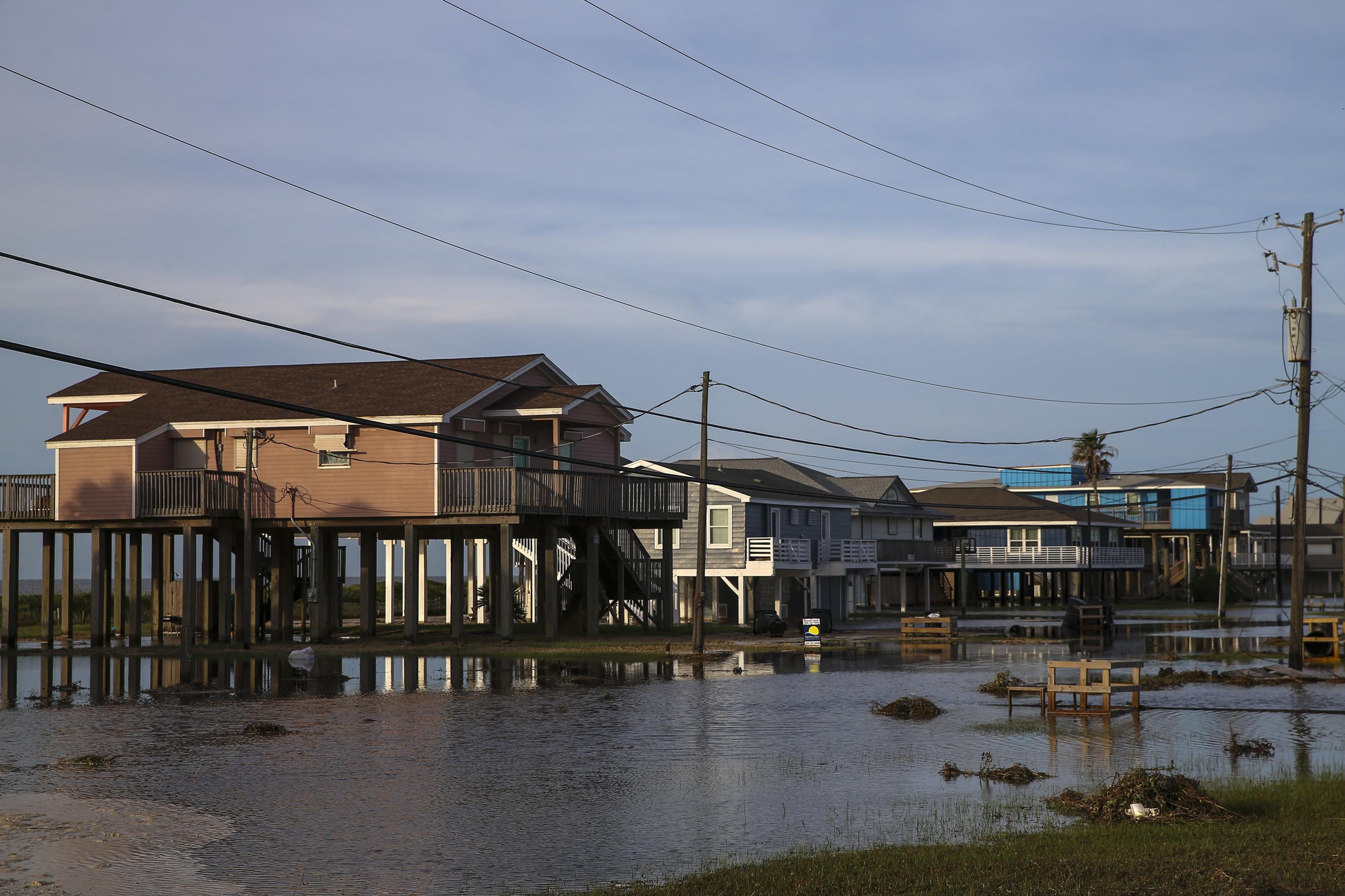 Big houses are seen behind a flooded area.