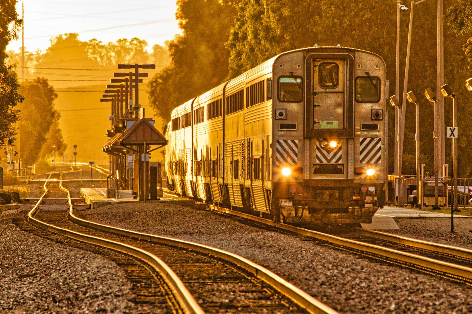 A double-decker Amtrak train in the golden hour of twilight.