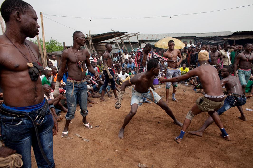 Lagos, Nigeria- A match between two fighters is stopped by another boxer in Lagos, Nigeria. Each match consists of three rounds. The match is stopped if a boxer's "spear" becomes unraveled or if one boxer hits the ground.